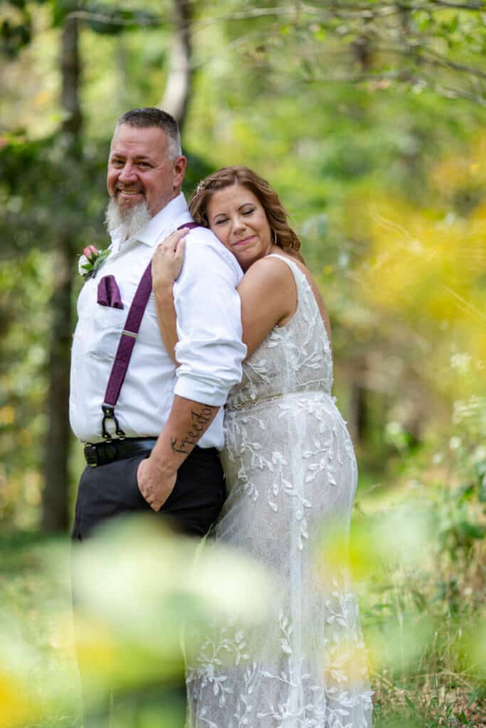 elopement bride and groom hug in wooded area