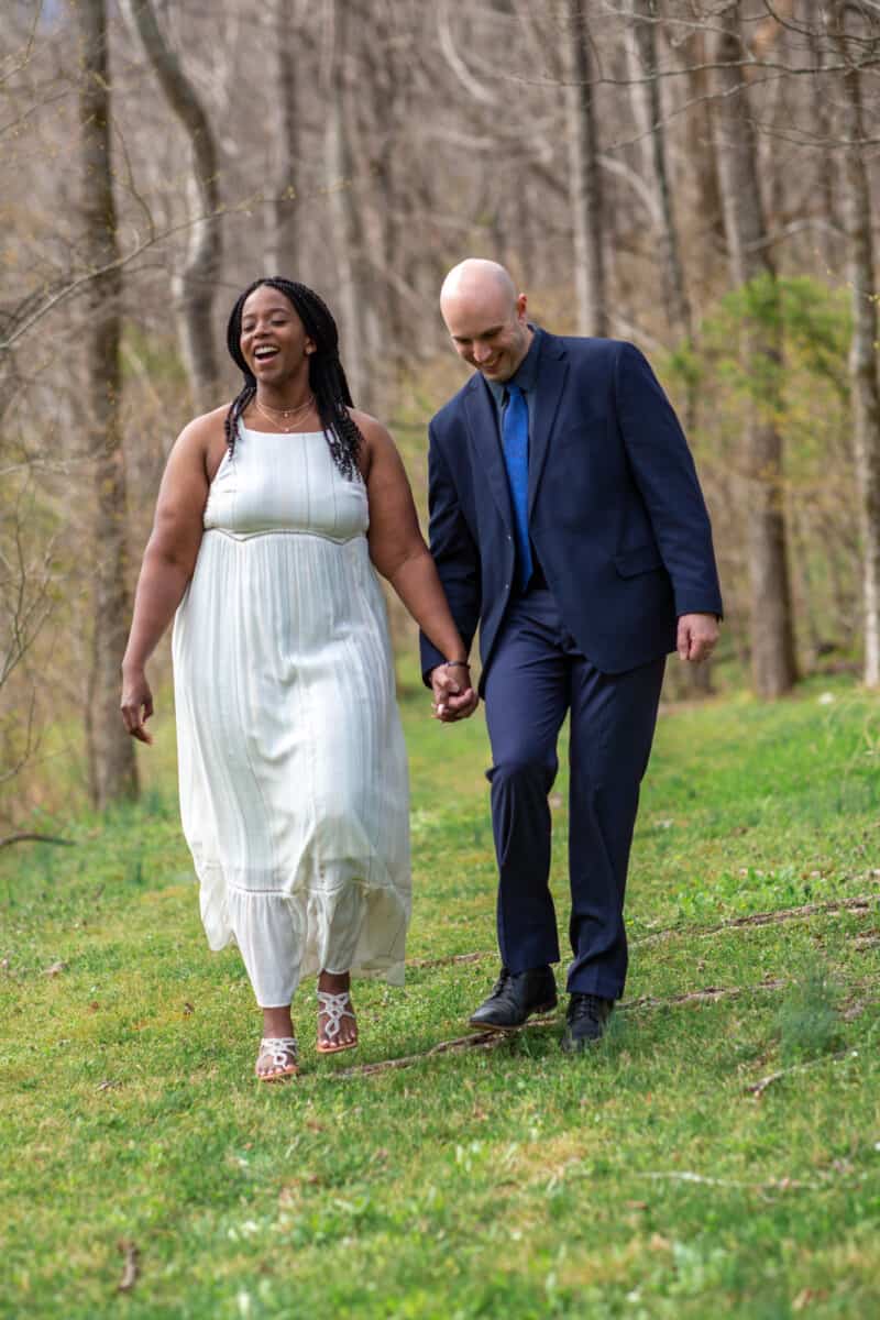 Spring Nashville Elopement at Butterfly Hollow; bride and groom take a walk near woods and laughing
