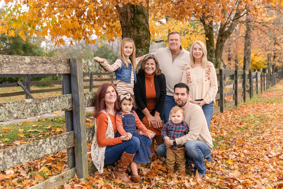 large family poses in fall leaves