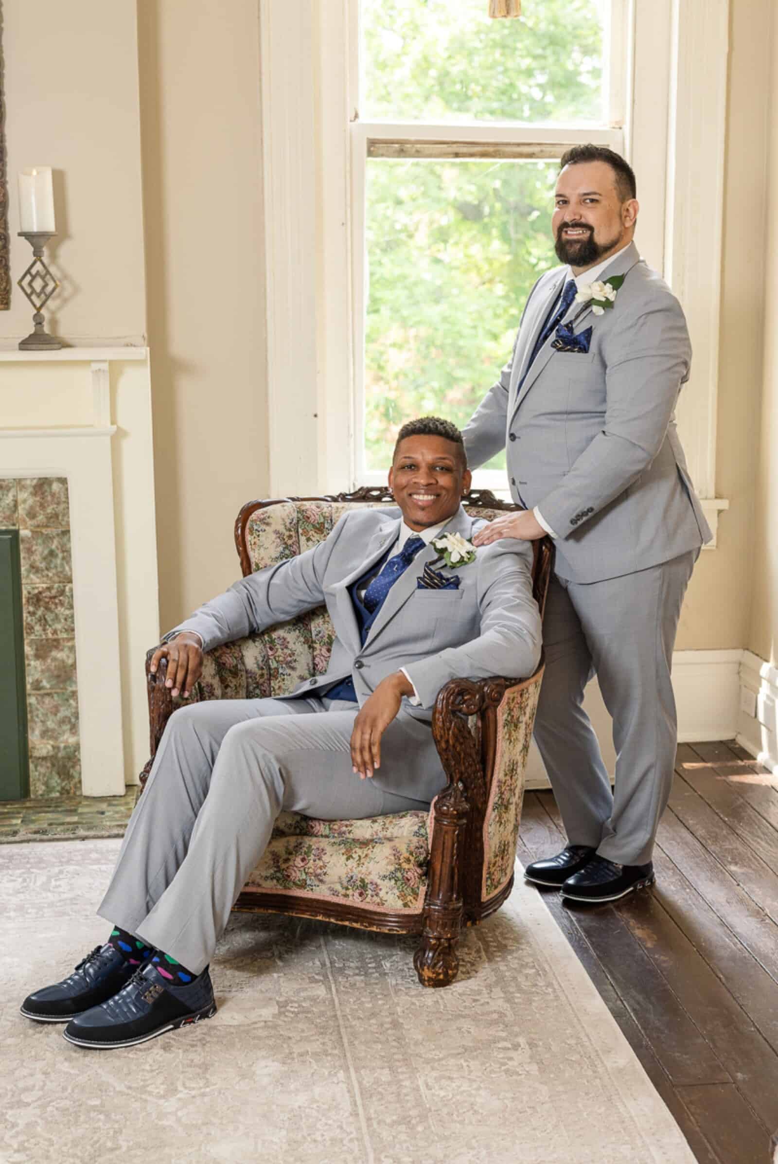 Same-sex male couple pose together inside antebellum mansion