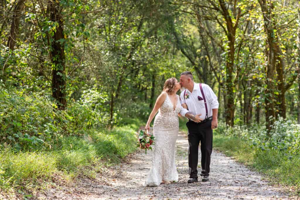 elopement bride and groom kiss on wooded path