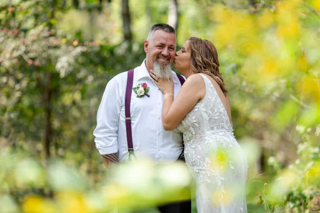 elopement bride and groom kiss in wooded area