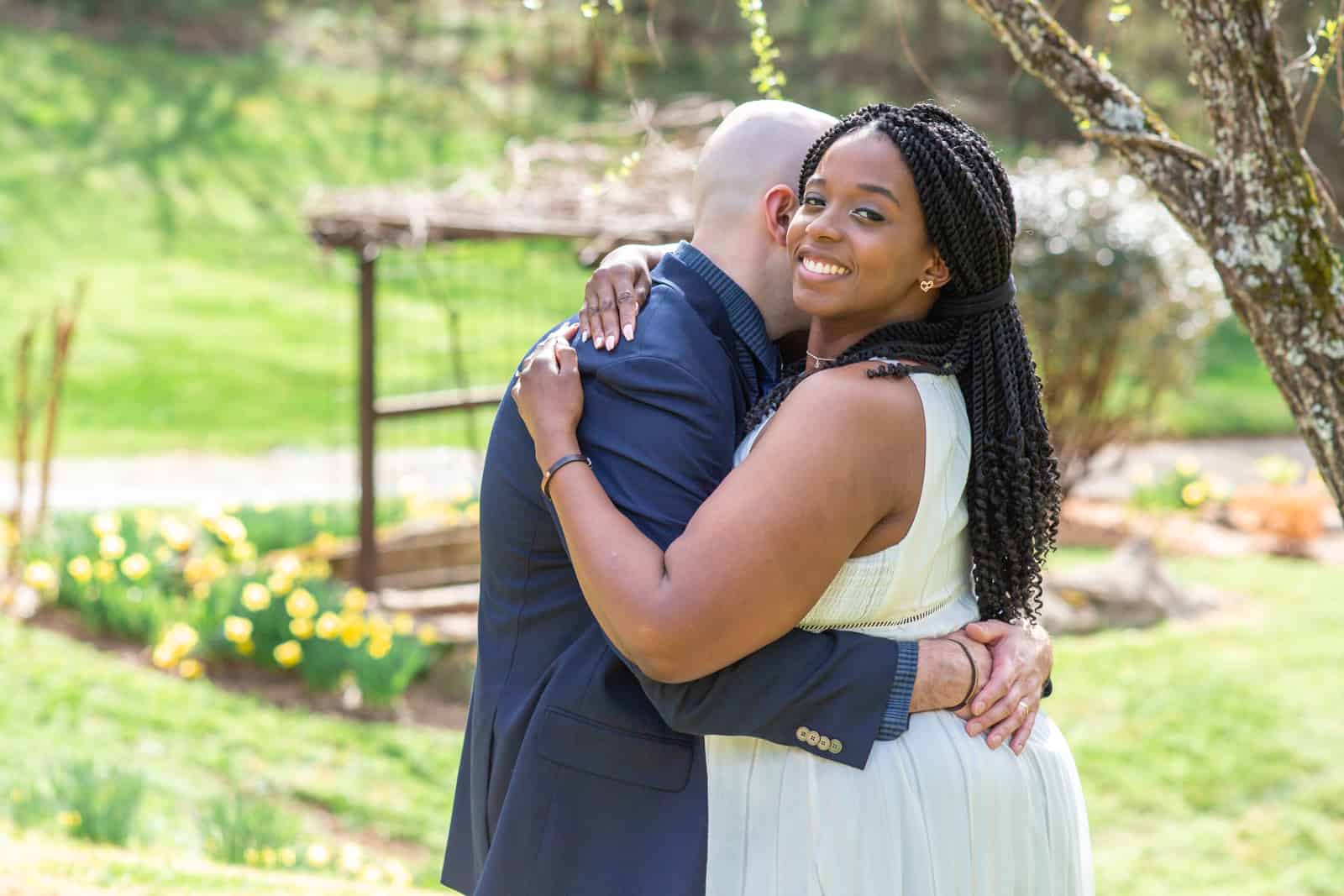 Spring Nashville Elopement at Butterfly Hollow; bride smiling at camera as groom hugs her