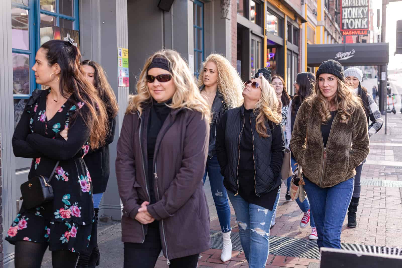 Women walking down street dressed in coats.