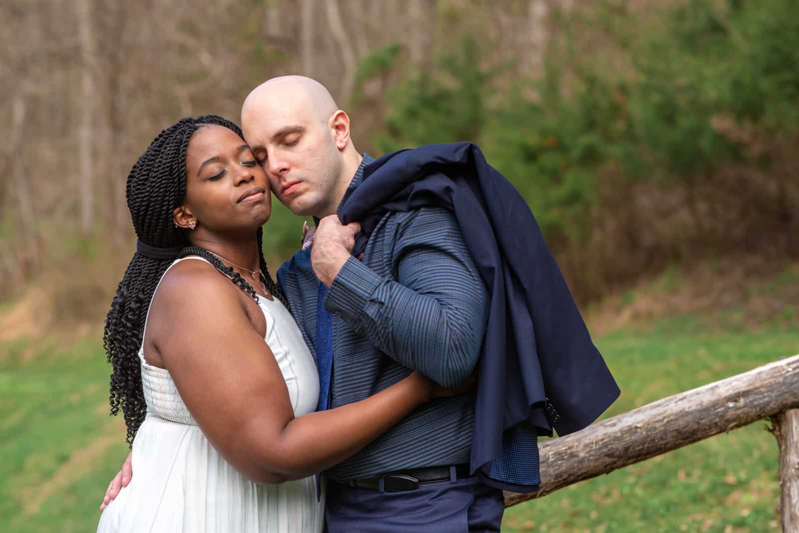 Spring Nashville Elopement at Butterfly Hollow; bride and groom embrace and he slings navy jacket over his shoulder
