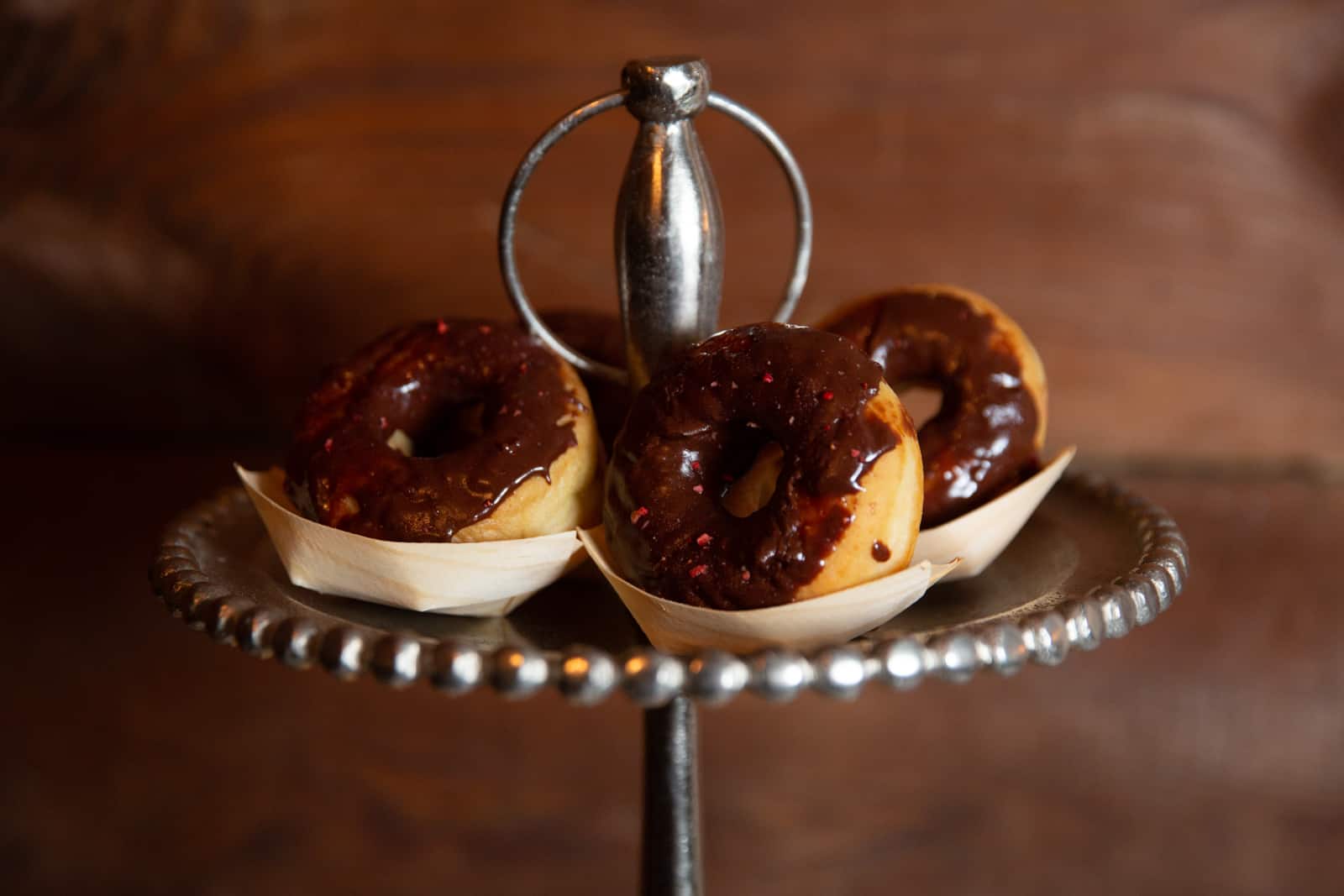 chocolate glazed donuts on silver platter