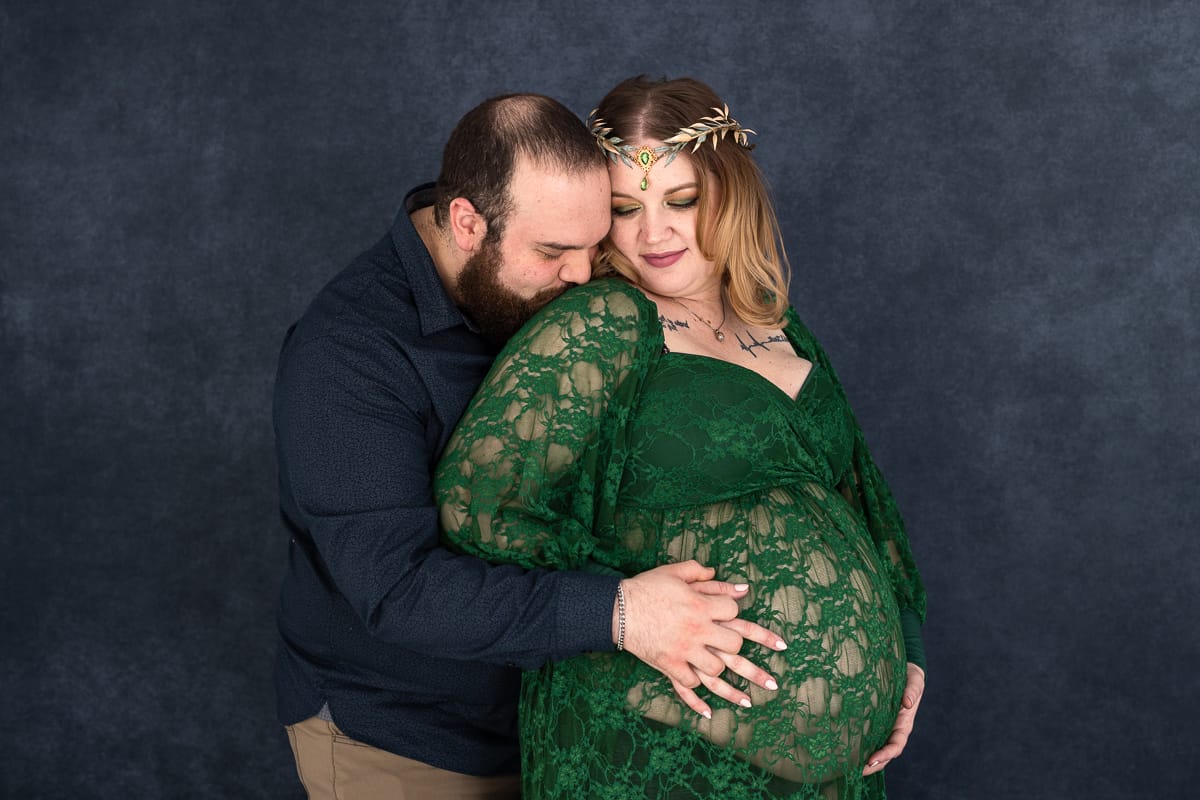 A couple snuggles together during a maternity photo session.