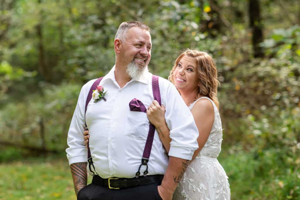 elopement bride and groom smiling in wooded area