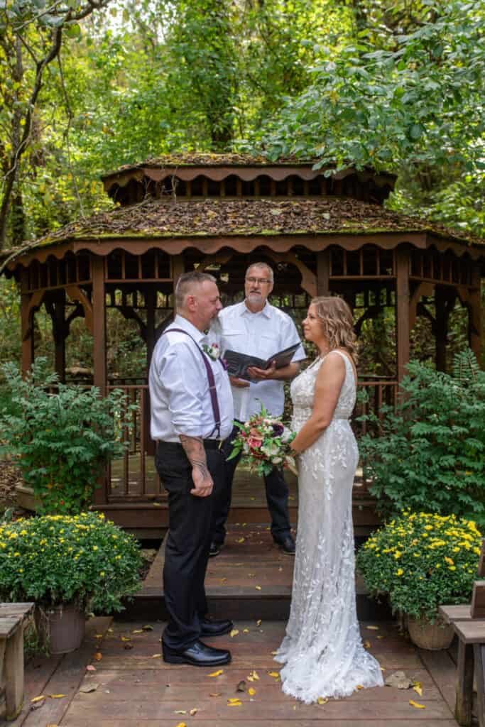 elopement bride and groom say their vows at gazebo in woods