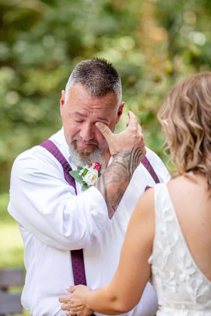 groom with tattoo wipes away tears