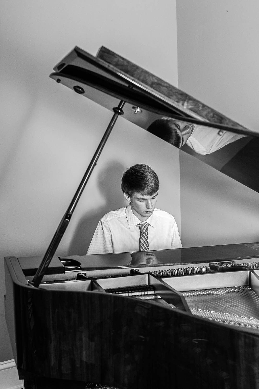 Young man plays grand piano